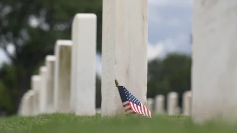 Slow Motion American Flag Waves next to Military Graves Video stock 117630753