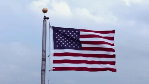 Slow Motion American Flag Waving in the Wind | 4K Aerial Drone Partial Orbit Stock Footage 334056950