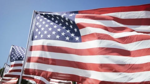 Slow motion american flags waving with a blue sky background. independence day Stock Footage 87779062