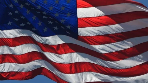 Slow Motion American US Flag Waving in Wind Against a Blue Sky Stock Footage 94880183