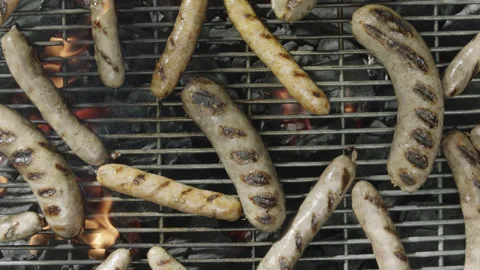Slow motion and close up view from above grilled sausages being fried over fire Video stock 145830916