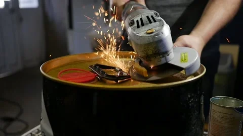 Slow motion of angle grinder and sparkles on metal barrel can. DIY project. man Stock Footage 143571618