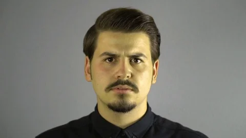 Slow motion angry young man screaming to camera. Grey dark background. Stock-Footage 76203462