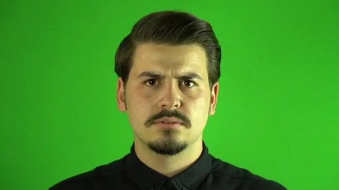 Slow motion angry young man screaming to camera. Greenbox background. Stock-Footage 76203463