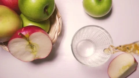Slow motion apple juice is poured into a glass top view Video stock 72152543