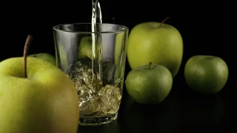 Slow motion. Apple juice pours into a glass on a black background Video stock 74920164