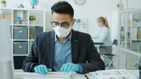 Slow motion of Arab man working with computer in office taking off face mask Stock Footage 131271939