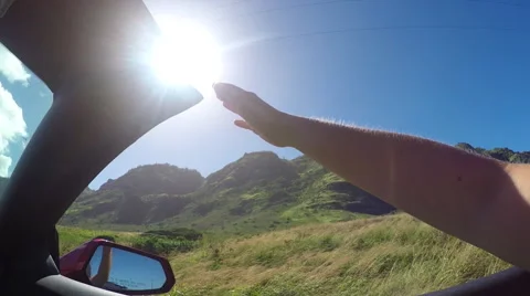 SLOW MOTION: Arm outside of convertible car playing with wind against sunny sky Stock Footage 63385505