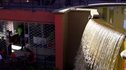Slow motion of an artificial waterfall, water falling slowly in a public park. Video stock 276573866