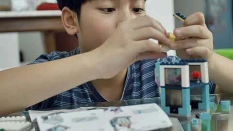 Slow motion of asian boy playing plastic block at home with smile face. Video stock 100745849