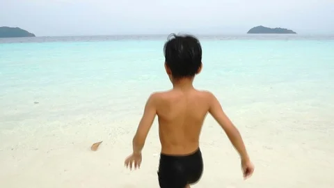 Slow motion Asian boy running to clear blue sea water at Andaman sea  Stock Footage 88437373