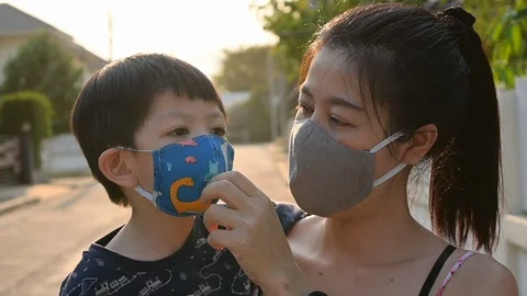 Slow motion, asian child boy and mother wearing fabric mask protect disease v Stock Footage 127360201