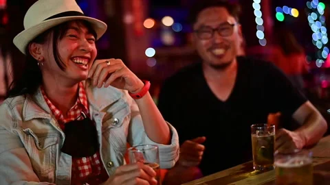 Slow motion of asian couple enjoying evening drinks in bar Stock Footage