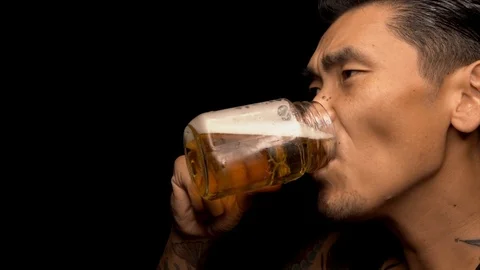 Slow motion of asian man drinking and chugging beer from a mug Stock Footage 94396112