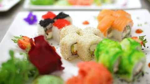 Slow motion assorted sushi sets decorated with romantic flowers and greenery Stock Footage 98777438