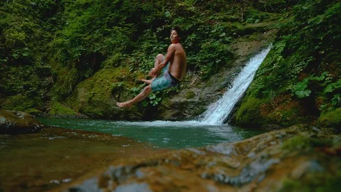 SLOW MOTION: Athletic man does a cannonball dive into a refreshing cold pond. Stock Footage 106595320