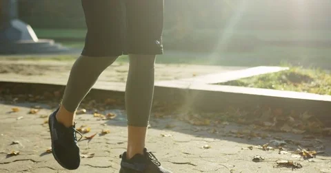 Slow motion of attractive man jogger walking in the park and taping on the phone Stock Footage 82507853