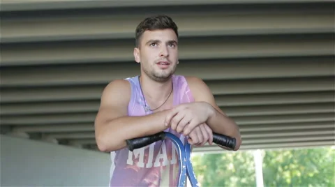 Slow motion. Attractive young athlete is resting after exercise outdoors. Stock Footage 68756146