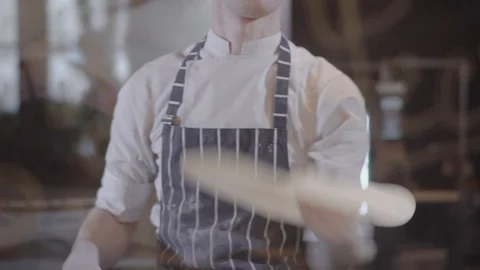 Slow motion of attractive young man spinning and tossing pizza dough up Stock Footage 104854189