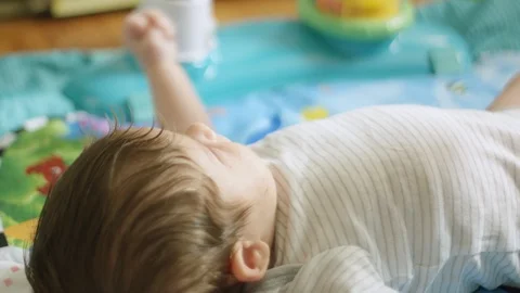 Slow motion of baby lying down in an activity learning gym Stock Footage 107612724