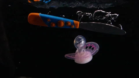 Slow Motion Baby Objects Falling in Water with Bubbles Parenting Video stock 133470666