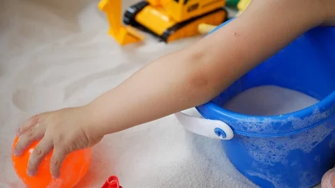 Slow motion, baby playing small ball on sand playground Stock Footage 89780171