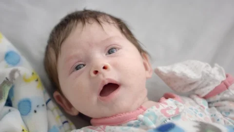Slow motion of baby's face looking around while lying down Stock Footage 107616043