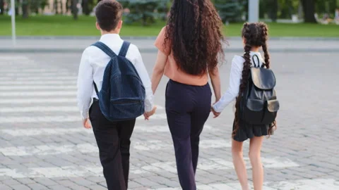 Slow motion back view mother woman with two children pupils schoolchildren Stock-Footage 158922788