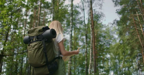 Slow motion back view: Young caucasian woman looking for direction on a map Stock Footage 137519537