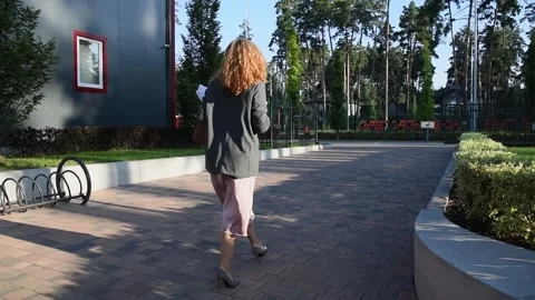 Slow motion back view of a young blonde business woman walking in morning 库存影片 332609814
