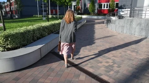 Slow motion back view of a young blonde business woman walking Vidéo 333039654