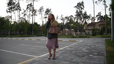 Slow motion back view of a young blonde woman walking through a park Vídeos de archivo 333070961