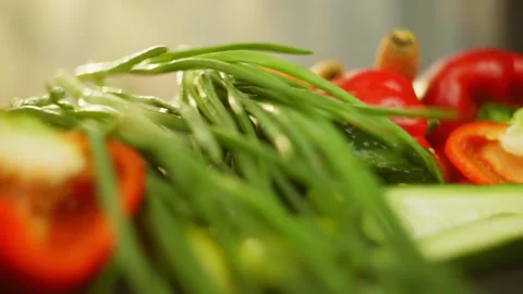 Slow motion background video of bunch green onions falling on fresh vegetables Stock Footage 296362002