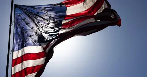 Slow Motion Backlit Real American Flag Waving In Wind Against a Deep Blue Sky Stock Footage 156266890