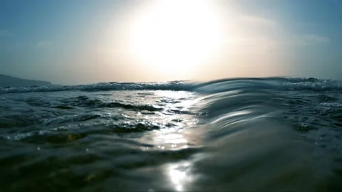Slow motion of backlit sea waves crashing on rocky beach. Stock-Footage 157857860