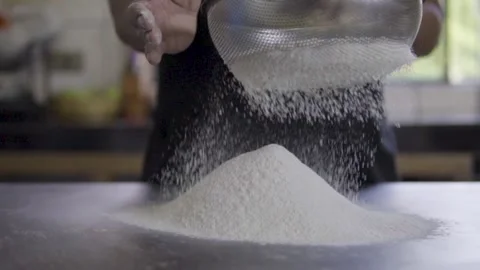 Slow motion of baker sifting flour Video stock 272495783