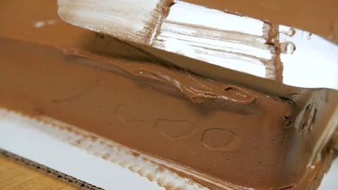 Slow motion baker smoothing edge of chocolate cake slow motion Stock-Footage 94249345