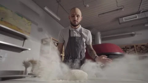 Slow motion. The baker throws the dough on the table with flour. Vídeo Stock 143430147
