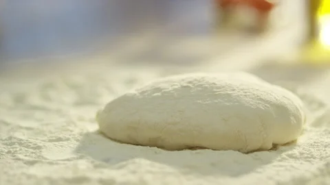 Slow motion ball of dough falls on flour on the table 4k Stock Footage 132974334