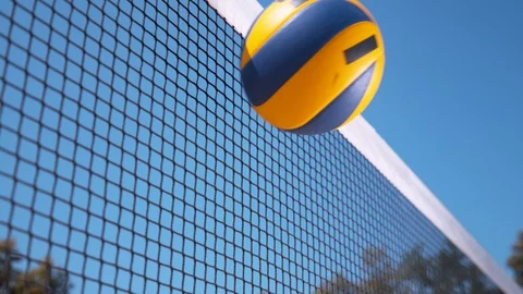 SLOW MOTION: Ball gets caught in a black and white net during volleyball game. Stock Footage 96727575