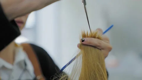 Slow Motion. The barber uses scissors to trim the ends of the hair to style.  Stock Footage 153955336