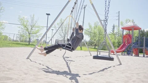 Slow motion of barefoot kid swinging in the park. Childhood leisure concept Stock Footage 242192899