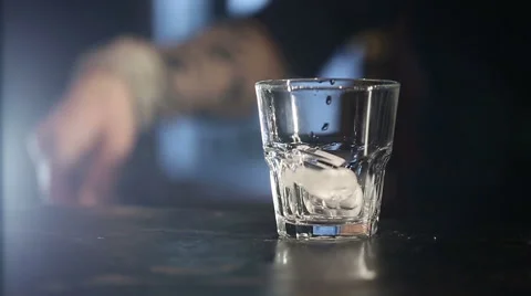 Slow Motion: Barman pouring a scotch whiskey with ice on the bar. Stock Footage