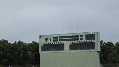 Slow motion baseball stadium scoreboard under a cloudy sky in Japan Video stock 348585688