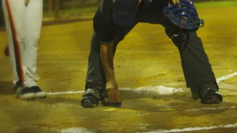 Slow motion of baseball umpire cleaning home plate Stock Footage