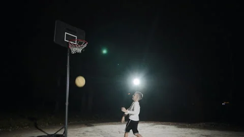 Slow motion basketball game featuring a boy practicing outdoors Stock Footage 293245800