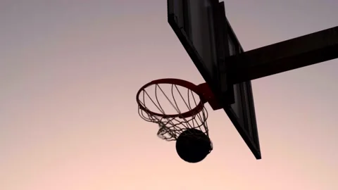 Slow motion of basketball scoring point at sunset, ball falling in the hoop Stock Footage 170310583