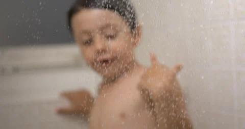 Slow-Motion Bath Time Elegance - Water Droplets in Foreground with Young Bo.. Stock Footage 250216883