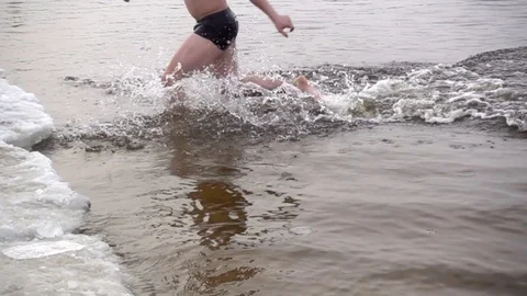 In slow motion, bathing in icy water and runs out onto the shore Stock Footage 84927157
