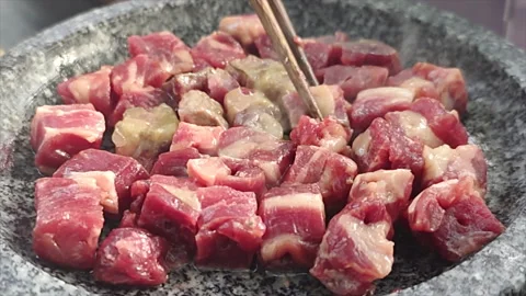 Slow Motion: Bbq Beef Fried in Stone Pot During an Outdoor Dining Stock Footage 165639279